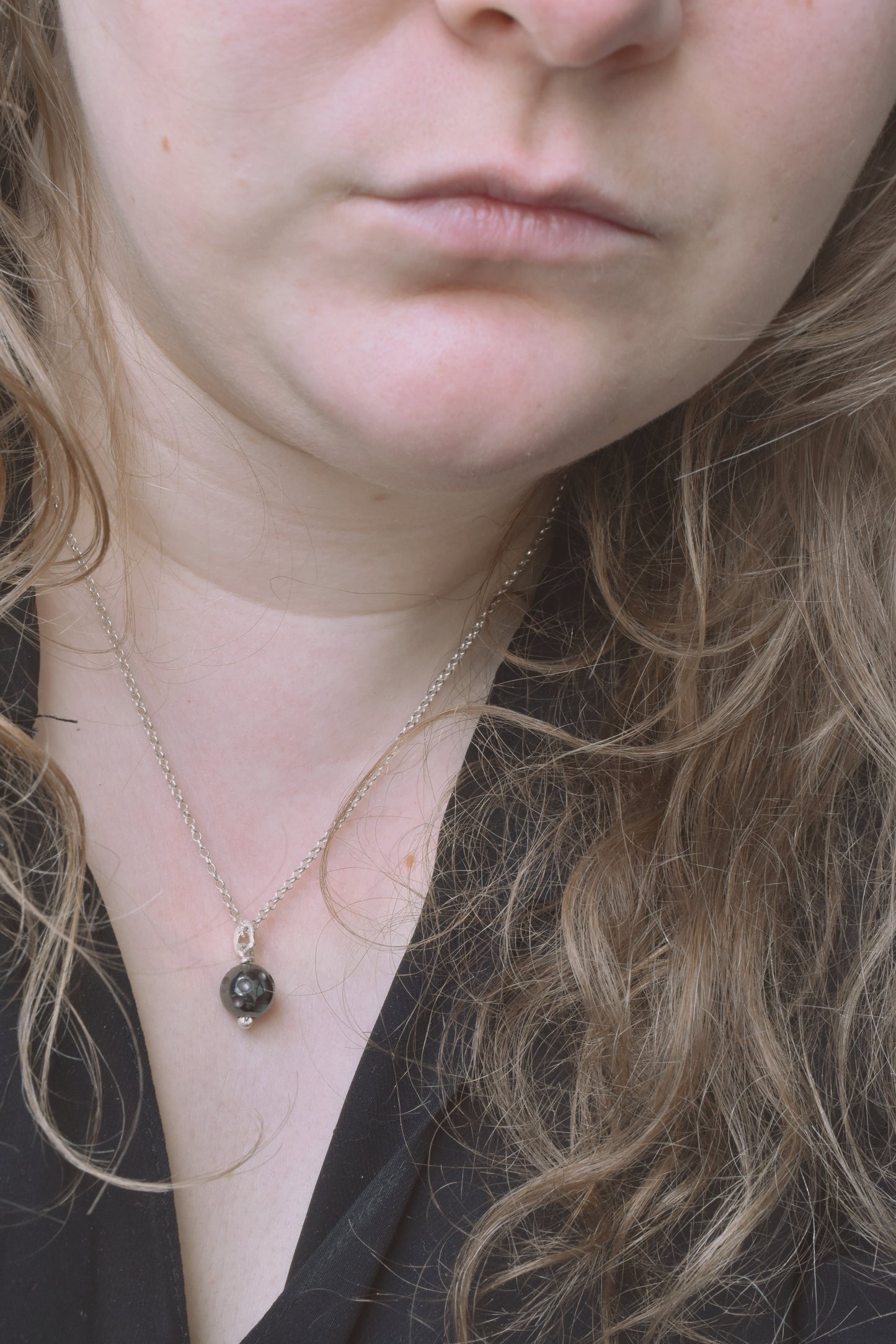 Silver hematite moon crater recycled silver pendant shown worn on neck