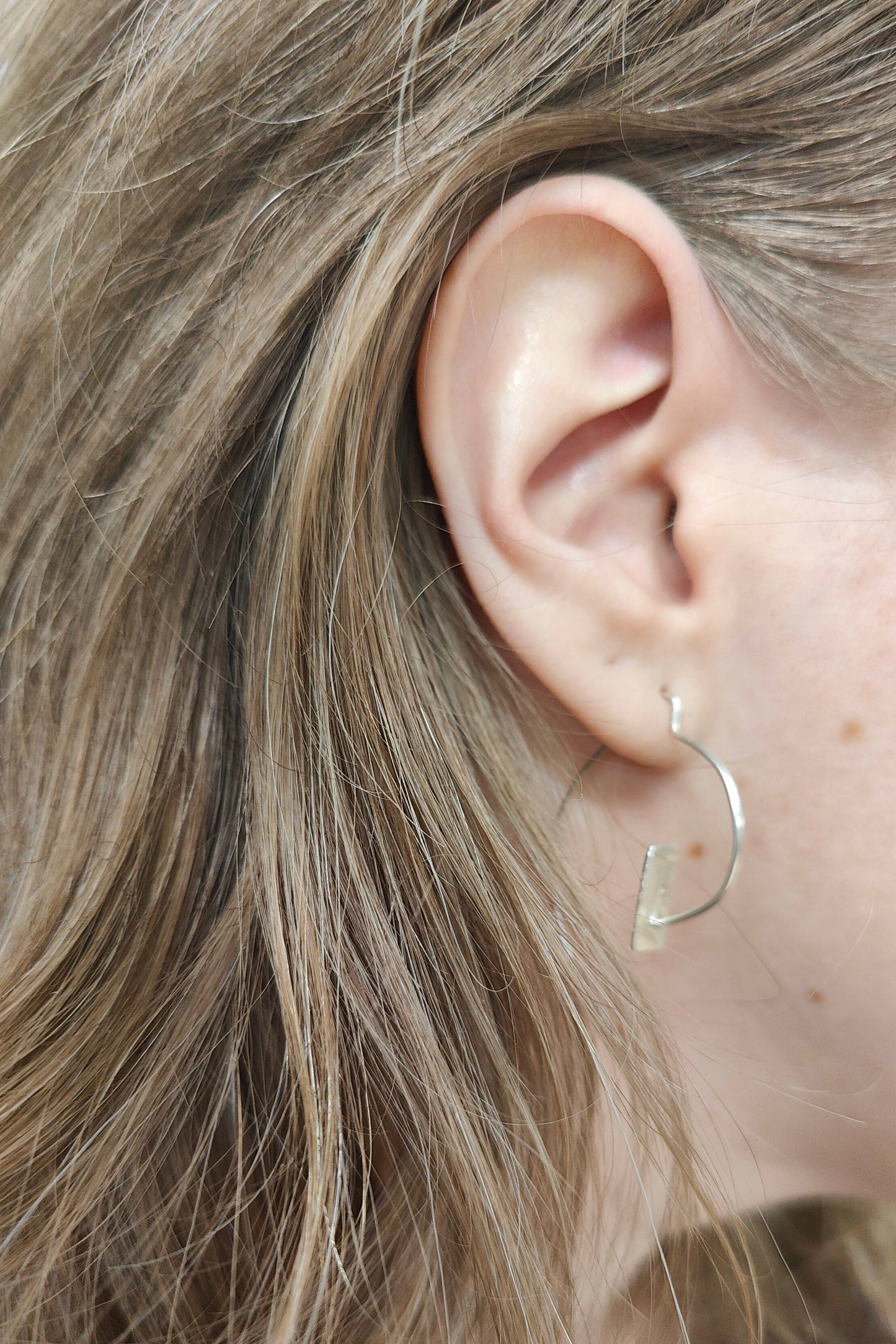 Silver spiral lightweight earrings shown worn on ear
