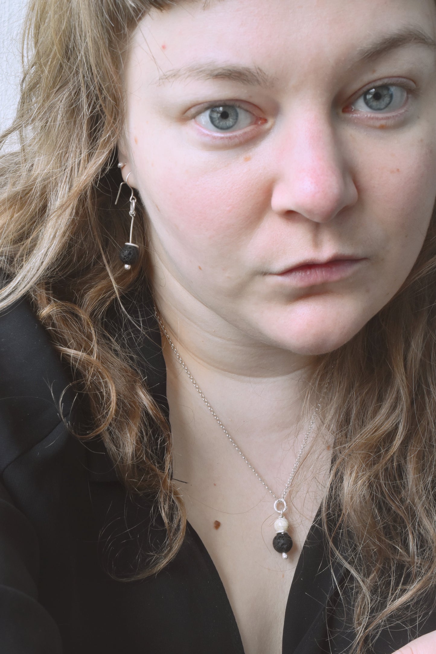 Lava stone silver earrings and pendant shown worn together