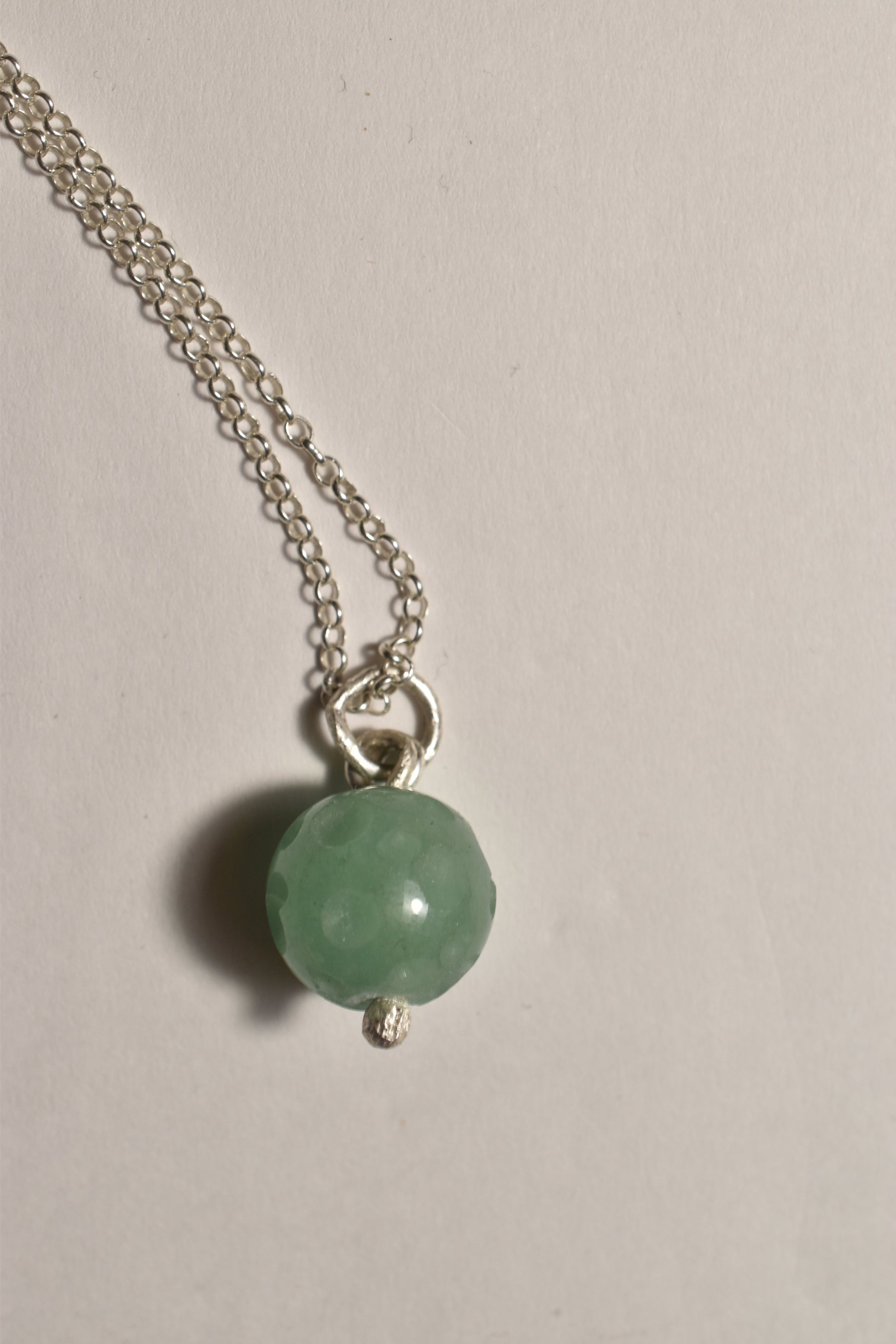 Aventurine silver pendant on silver chain, on a white background with shadow