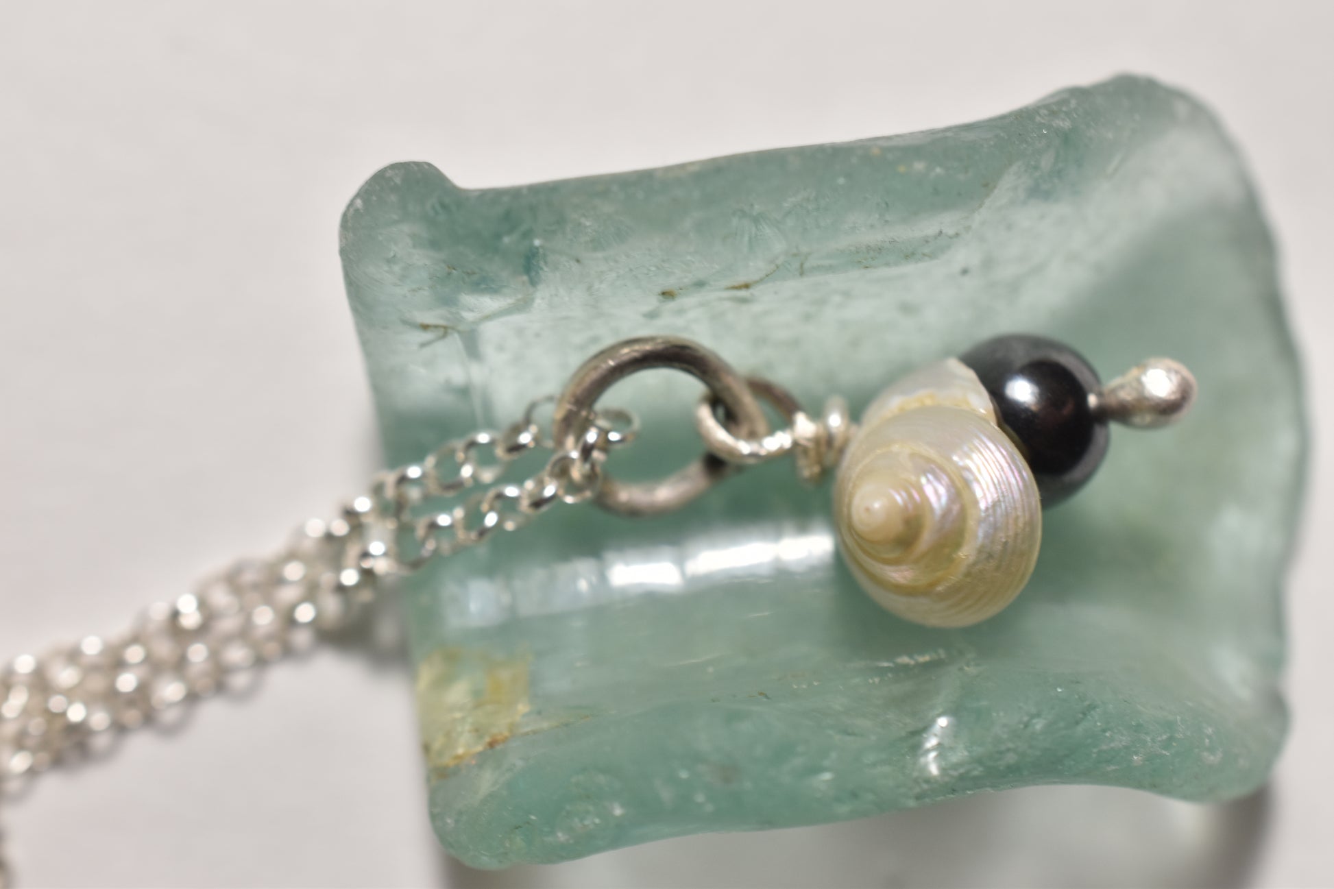 Silver seashell and hematite handmade pendant, close-up of delicate shell