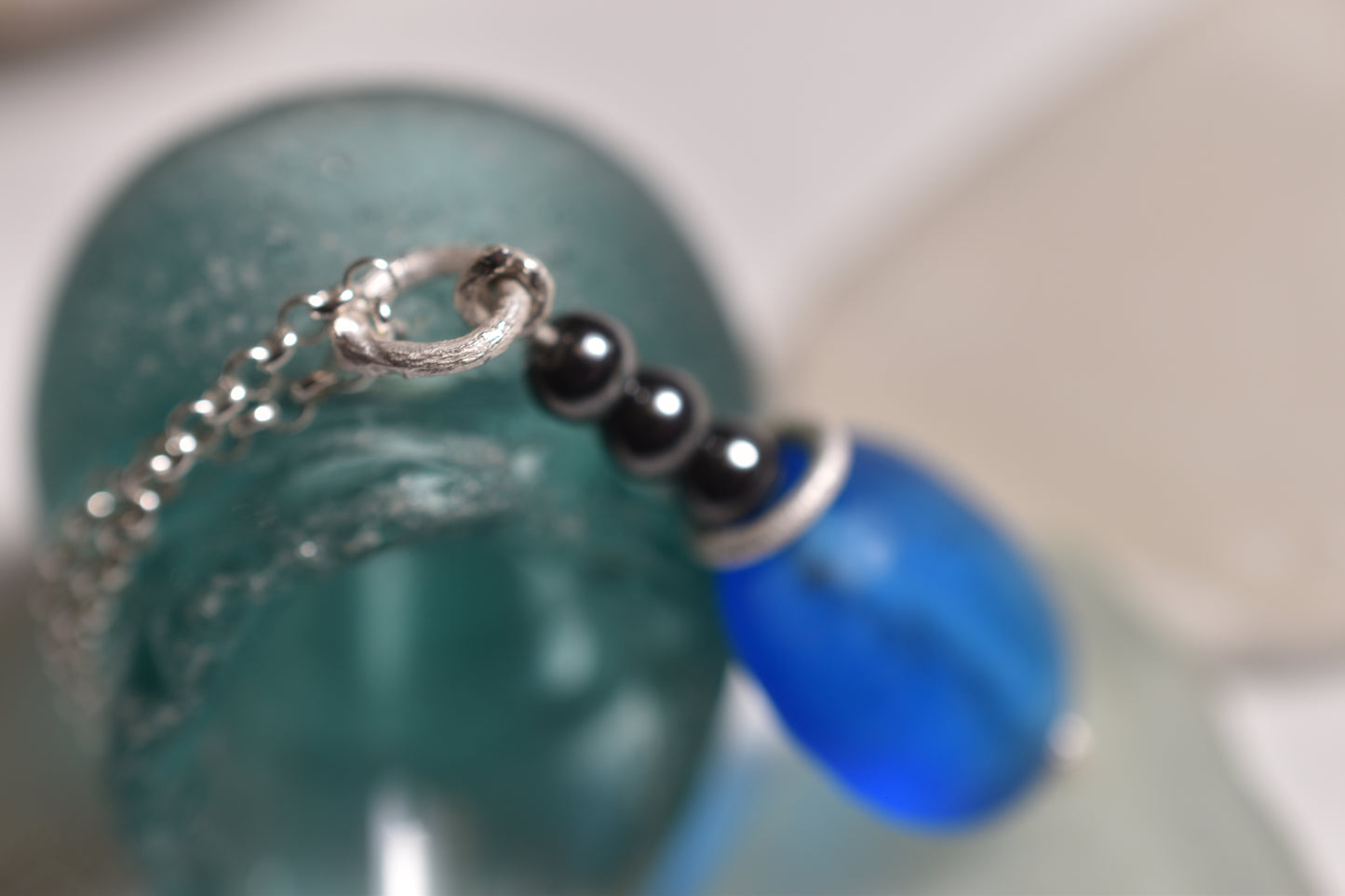 Blue glass bead pendant with three hematite beads on sterling silver chain