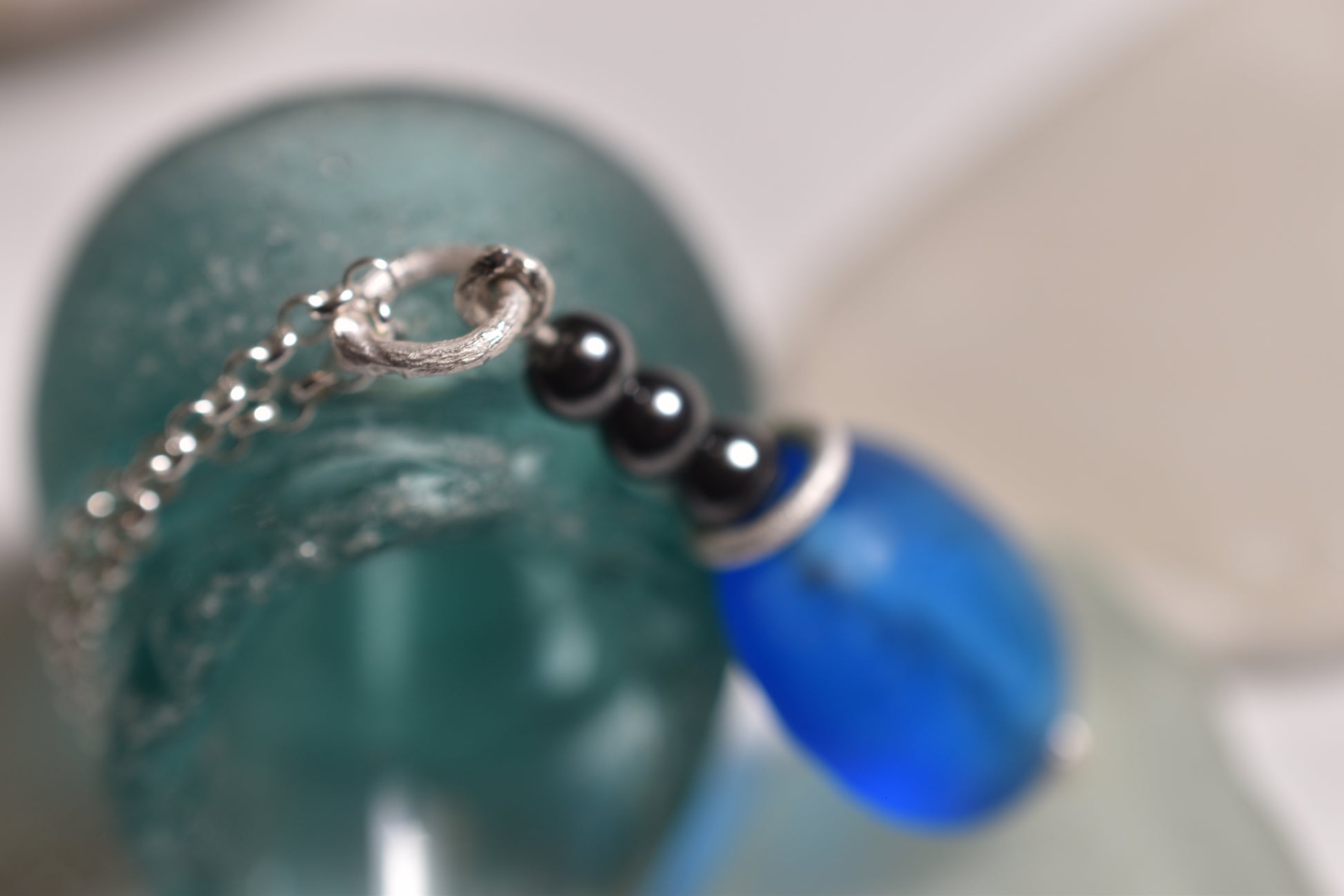 Blue glass bead pendant with three hematite beads on sterling silver chain