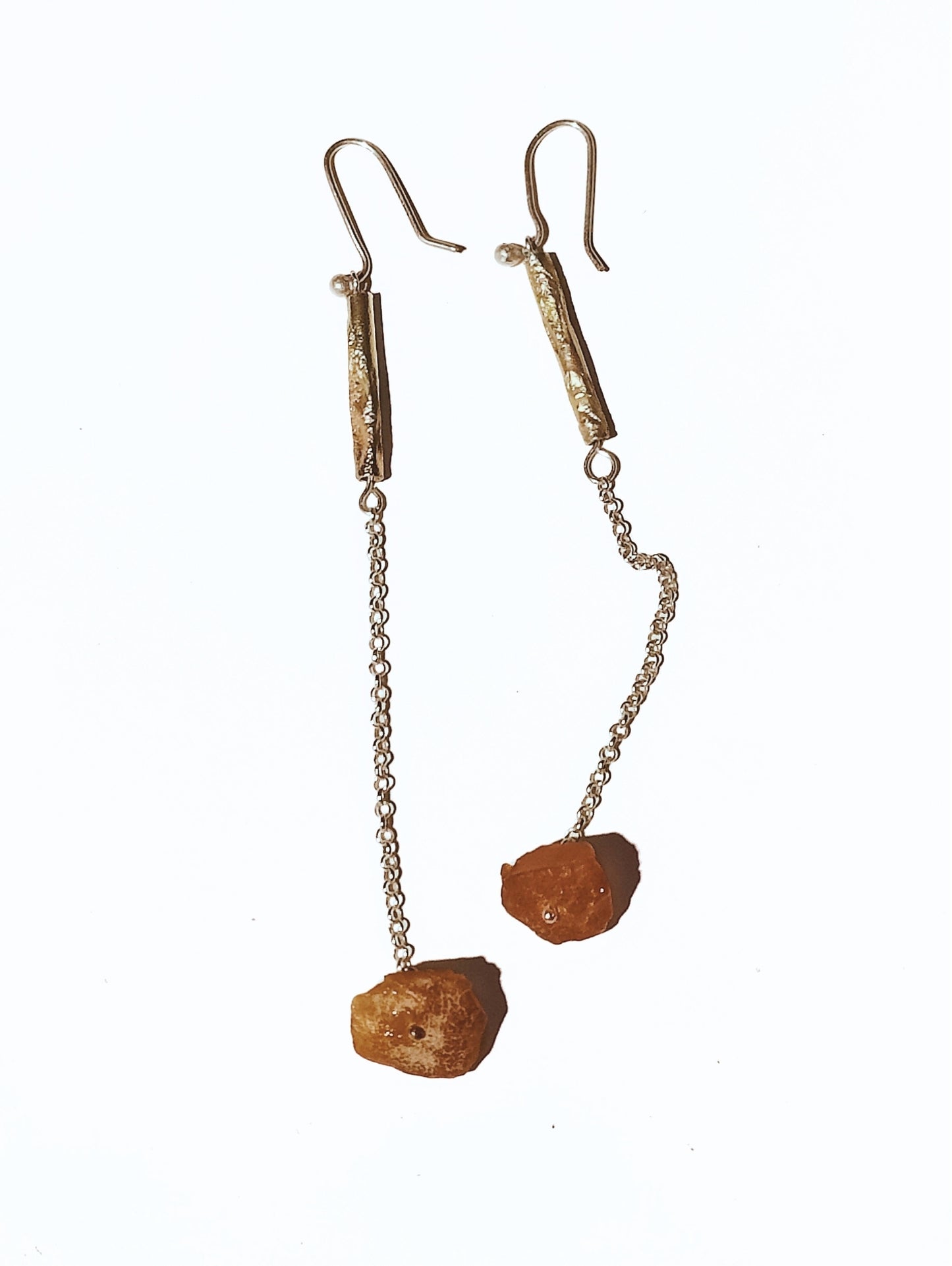 Long Fool's Gold earrings with amber shown on a white surface