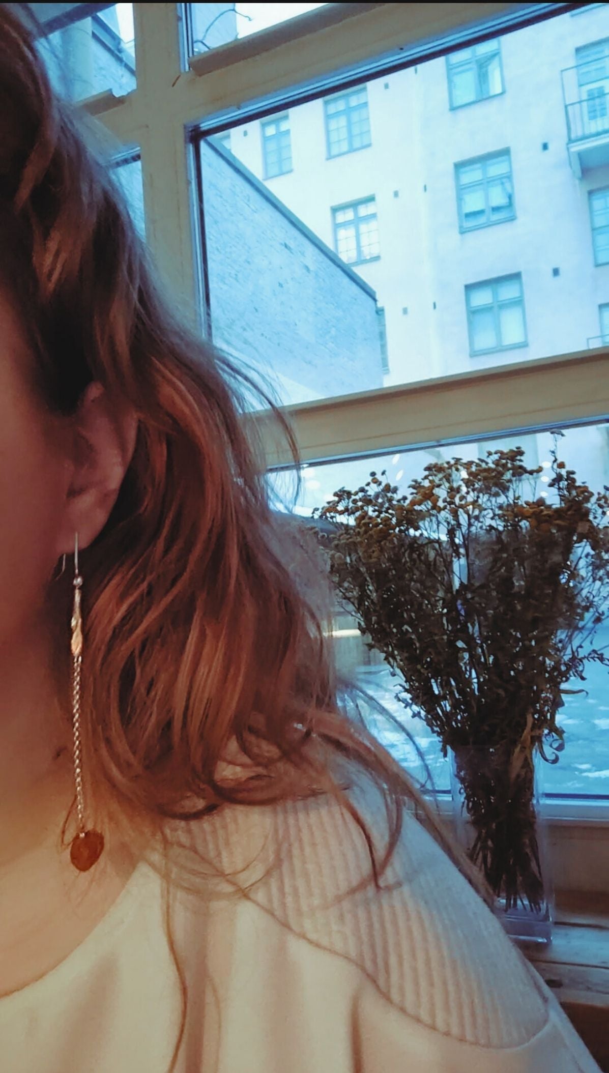 Long Fool's Gold handmade earrings with amber, worn on ear