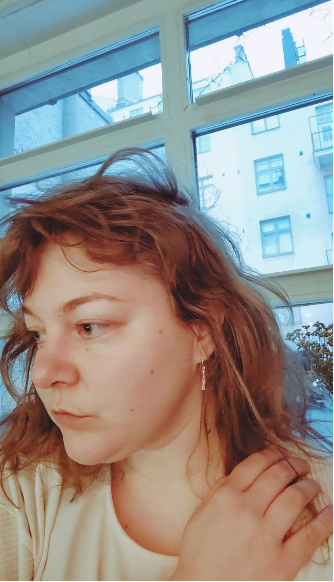 Short Fool's Gold earrings with brass and silver, worn on ear