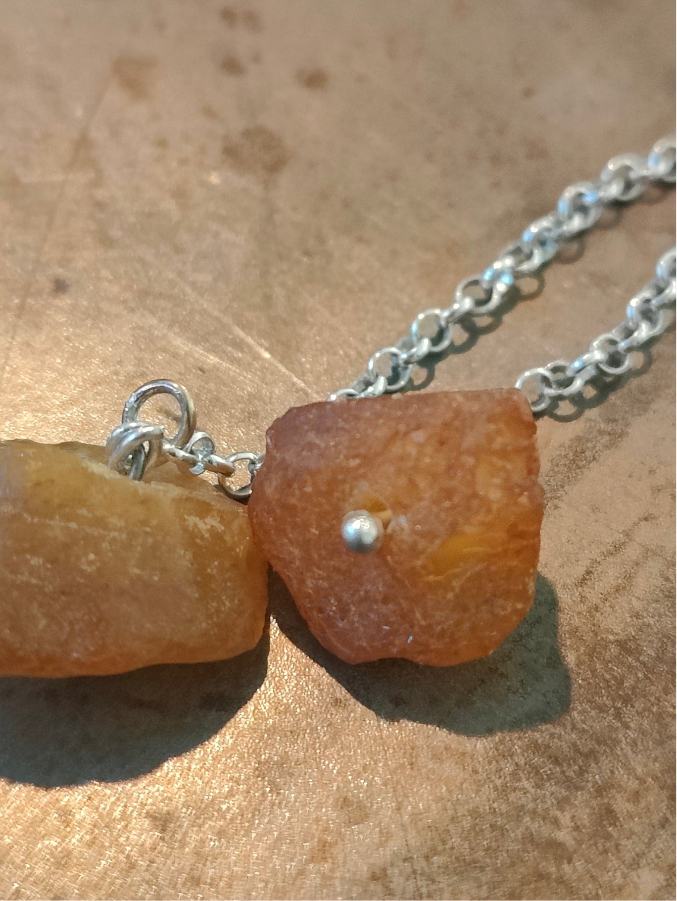 Long Fool's Gold earrings with brass and amber beads, close-up