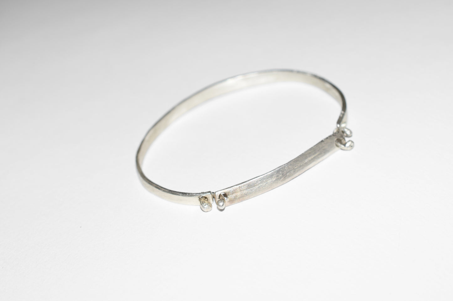 Orbit handmade silver bracelet with rough brushed texture, close-up detail