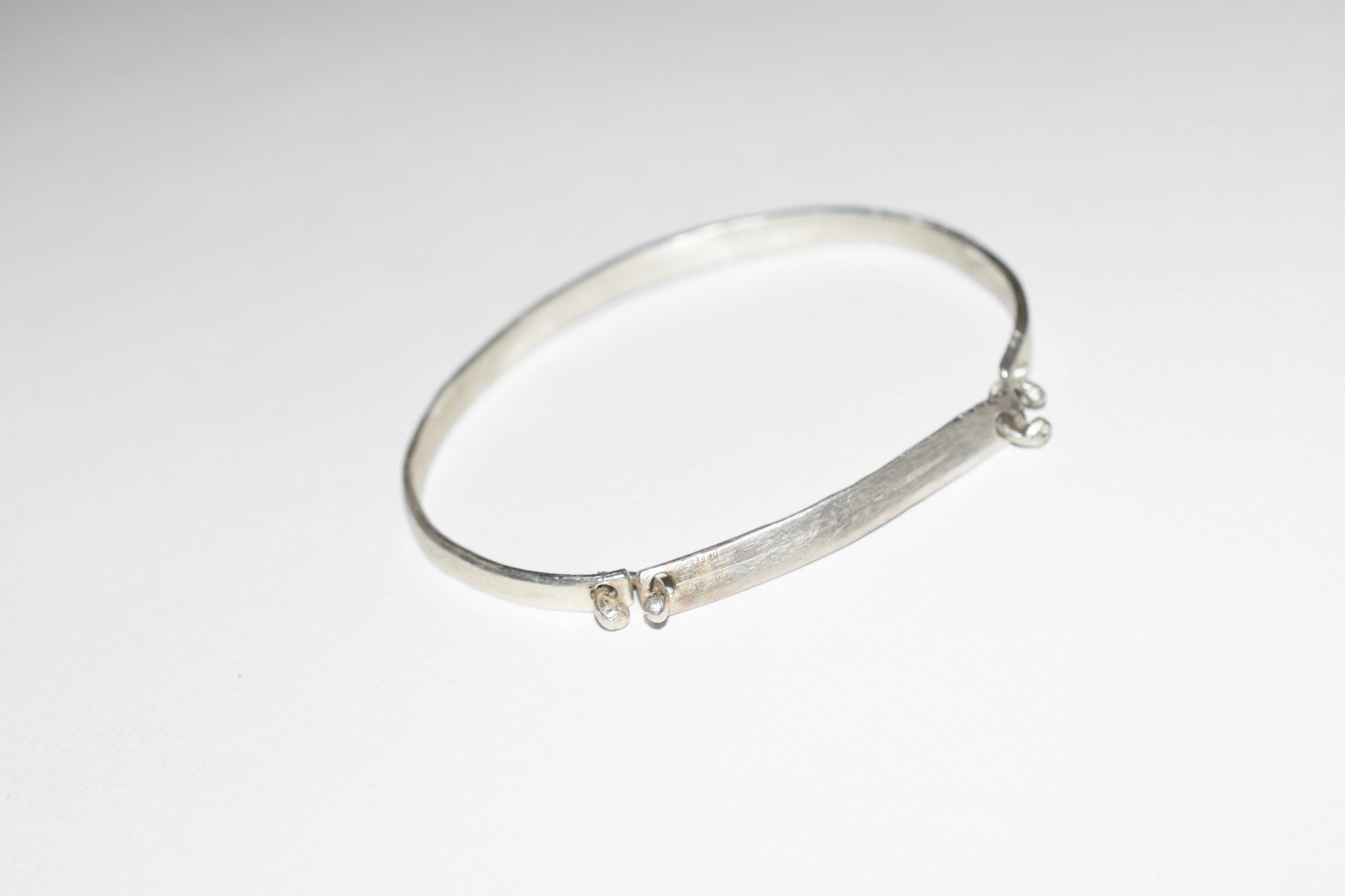 Orbit handmade silver bracelet with rough brushed texture, close-up detail