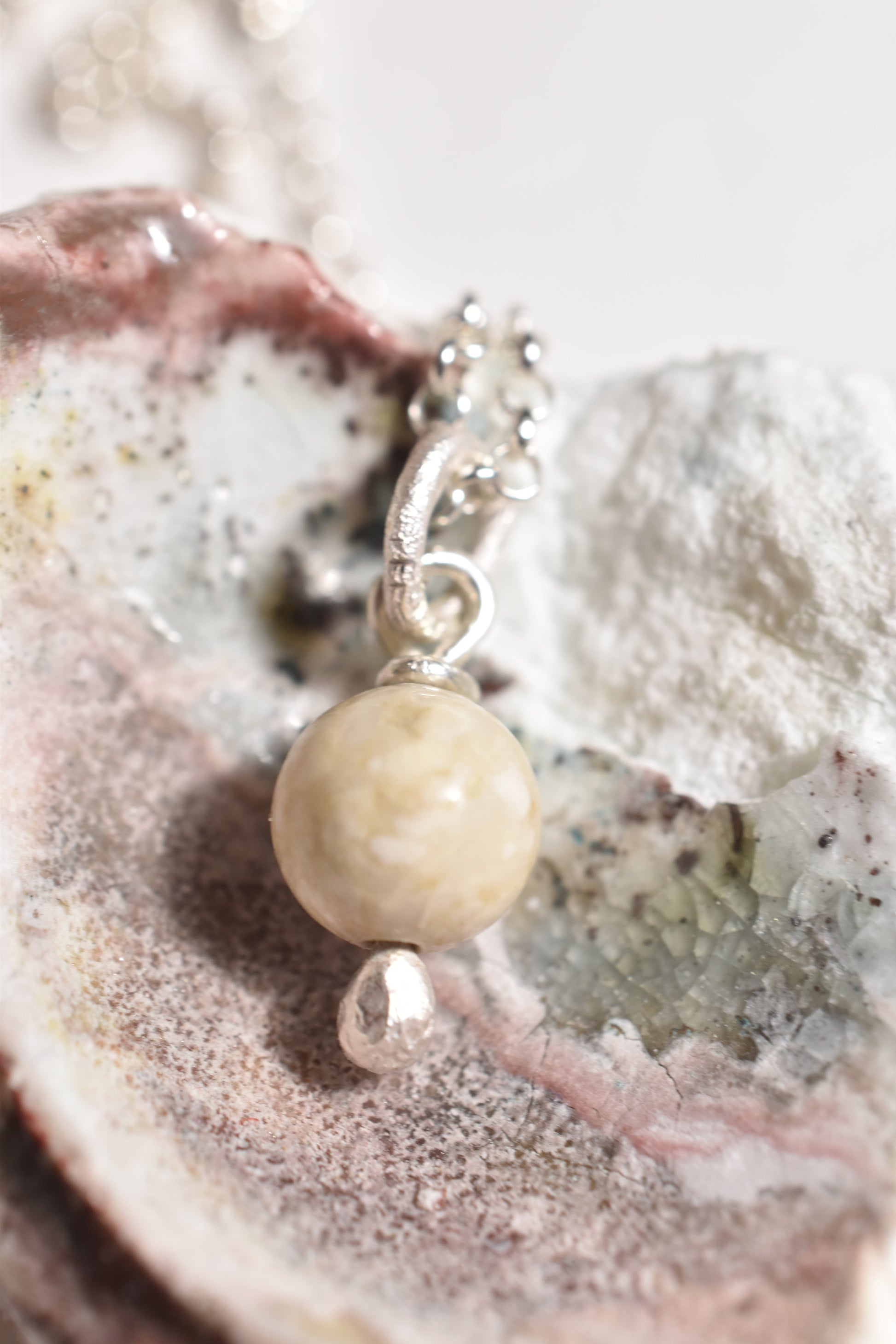 Silver white stone handmade charm, close-up detail of natural stone