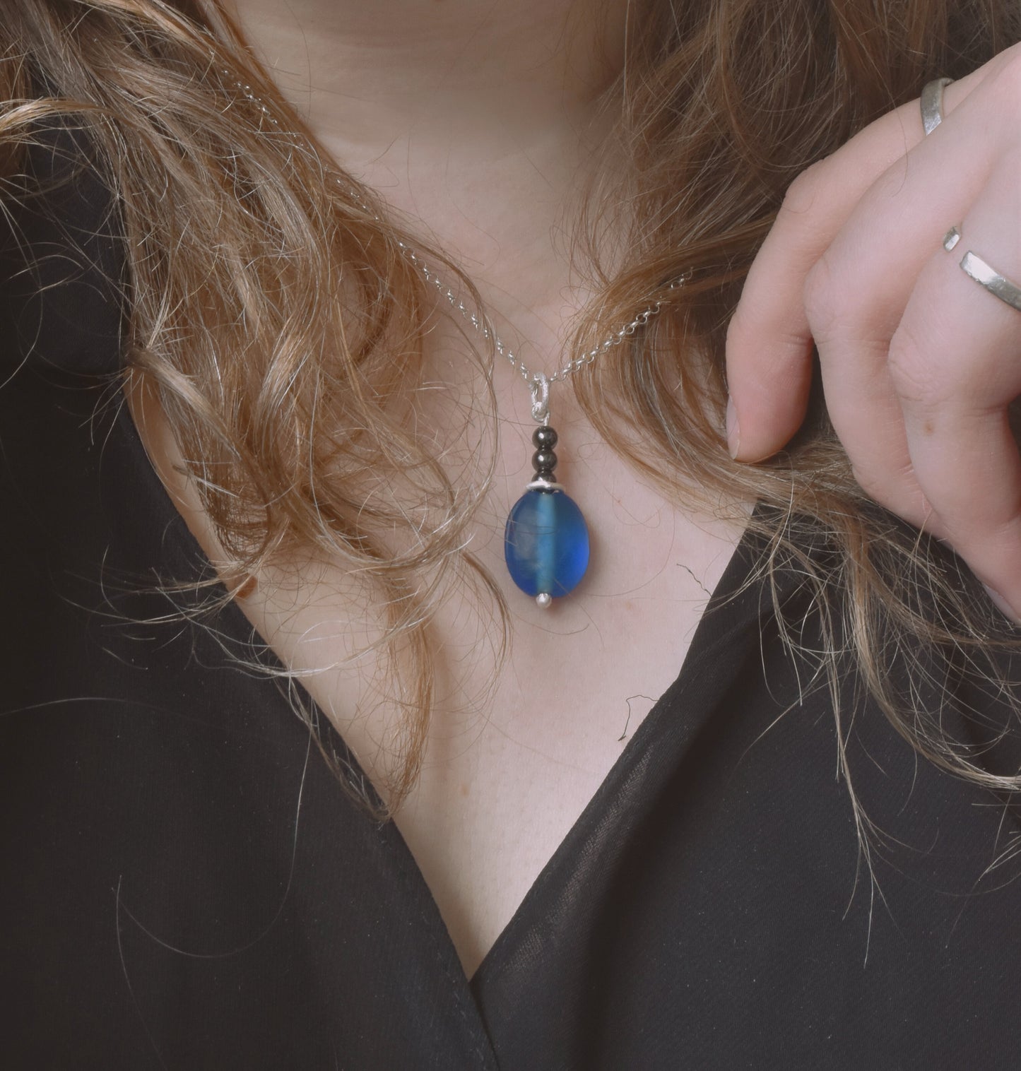 Blue glass and hematite recycled silver pendant shown worn on neck