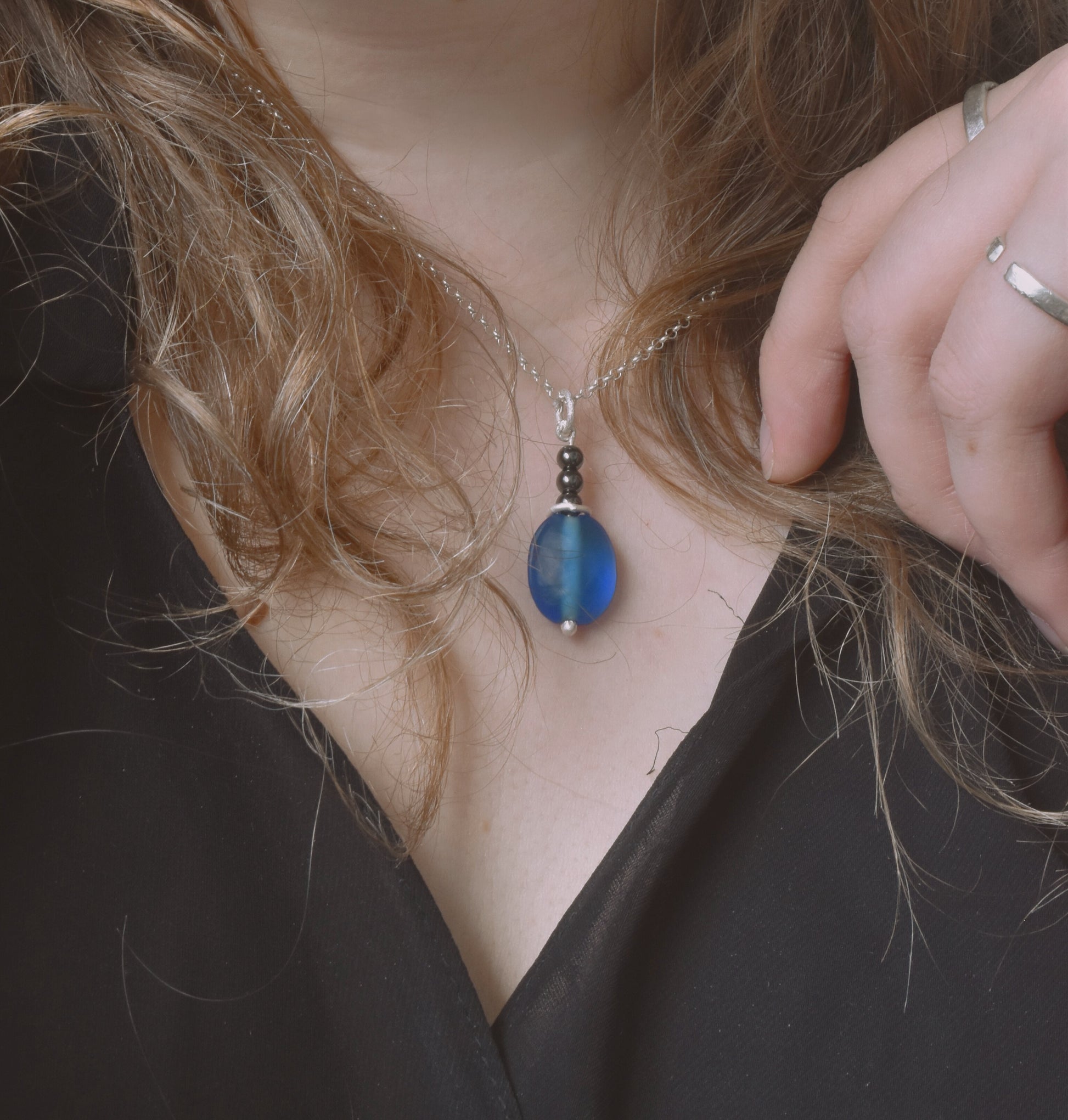 Blue glass and hematite recycled silver pendant shown worn on neck